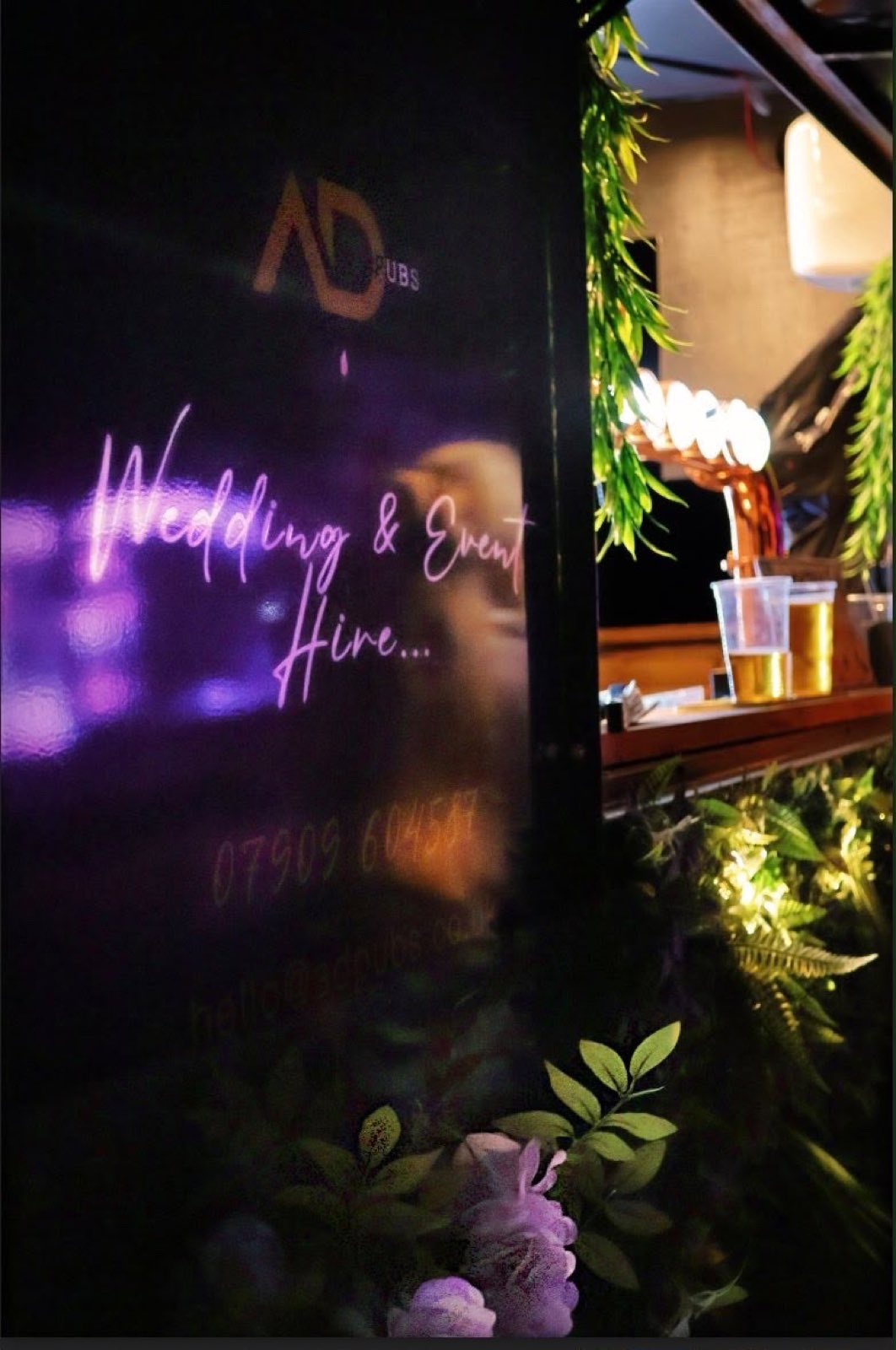 The wedding and event hire signage glowing on the bar at night.