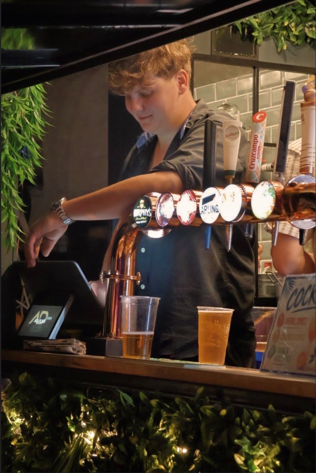One of the ADevents team pouring a pint at the copper font.