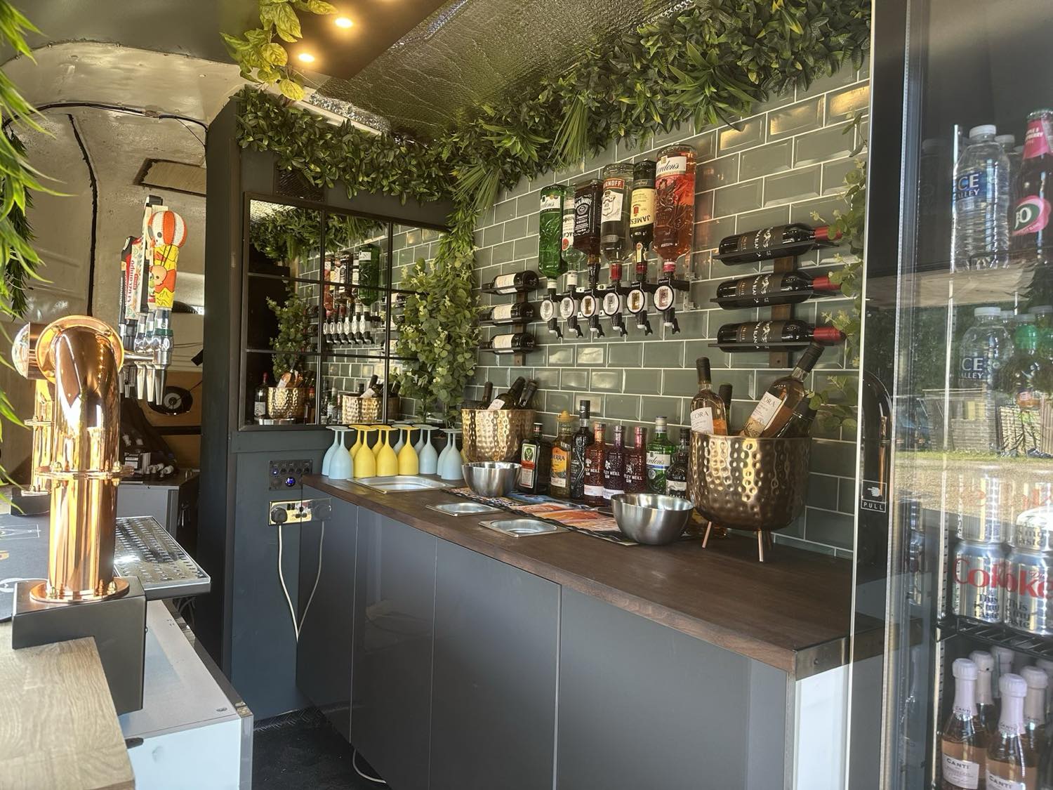 Inside the horsebox bar - copper tap font, wine racks, ice buckets and a drinks fridge.